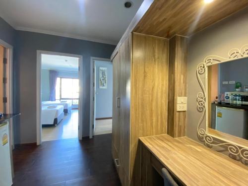 a room with a mirror and a bedroom at Tamnan Resort Pattaya in Ban Nong Chaeng