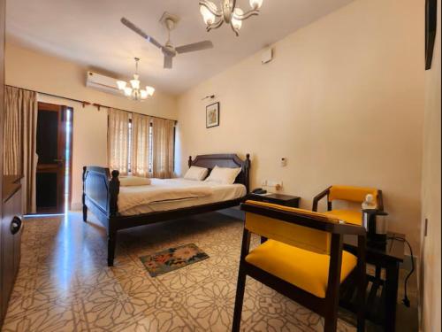 a bedroom with a bed and a table and a desk at Lukochurri in Shānti Niketan