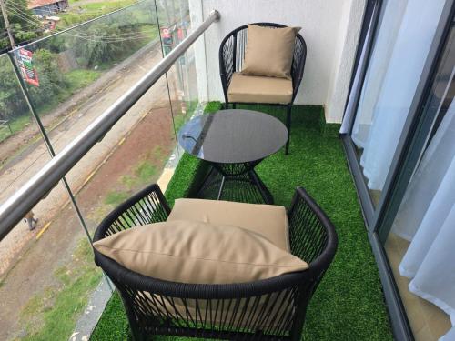 a balcony with a table and chairs and a table and a chair at Ideal homes in Gatunga