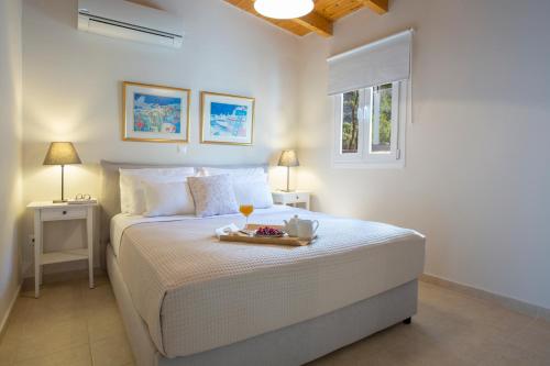 a bedroom with a bed with a tray of food on it at Villa Avlaki in Vlikhón