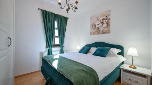 a bedroom with a green bed with a window at Dvori Perdedaj by Villas Guide in Beretinec