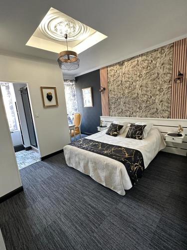 a bedroom with a large bed and a wall at Le clos fleuri in Saint-Gervazy