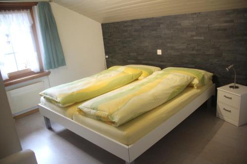 ザース・グルントにあるApartments Sarazenaのベッドルーム1室(黄色いシーツと窓付)