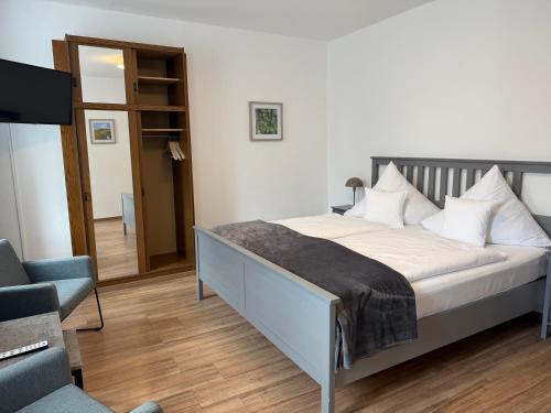 a bedroom with a bed and a chair and a television at RATSKELLER Hotel & Restaurant in Kröv