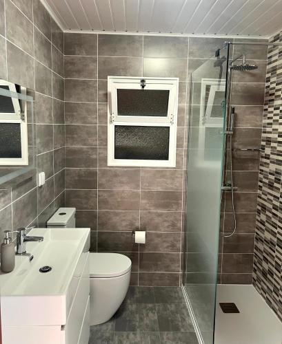 a bathroom with a shower and a toilet and a sink at Mein Faial, Apartment with Pico and Seaview in Horta