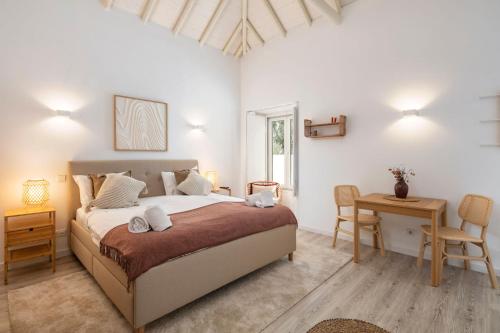 a bedroom with a bed and a table and chairs at Alma da Vida Ferragudo in Ferragudo