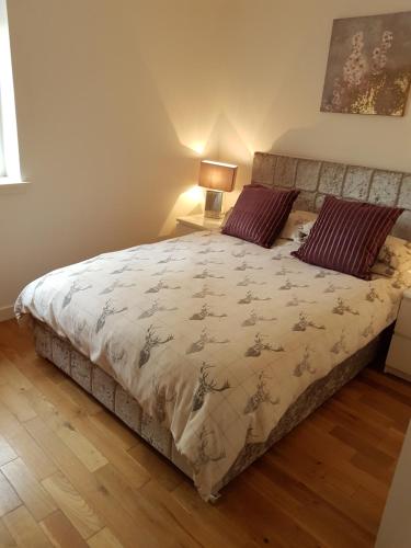 a bedroom with a large bed with two pillows at Langley Apartment in Inverness