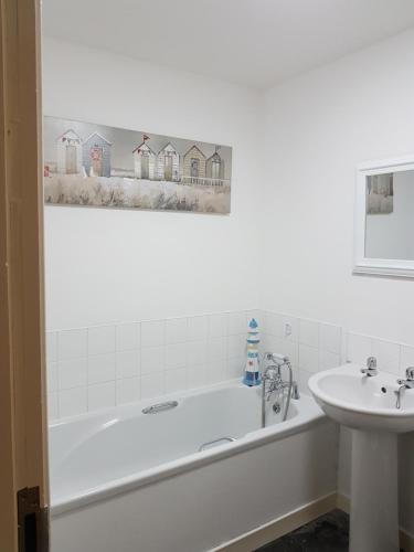 a bathroom with a bath tub and a sink at Langley Apartment in Inverness