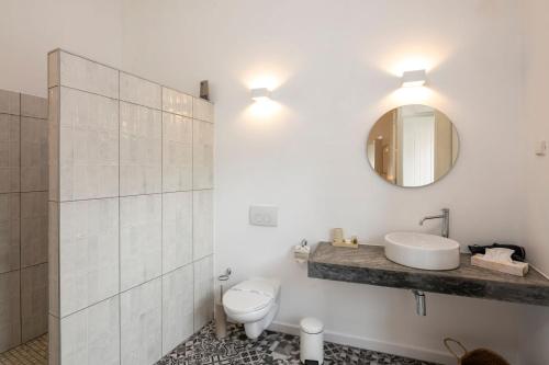 a bathroom with a toilet and a sink and a mirror at Alma da Vida Ferragudo in Ferragudo