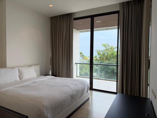 a bedroom with a bed and a large window at The 211 Rayong in Ban Phlong Sawai