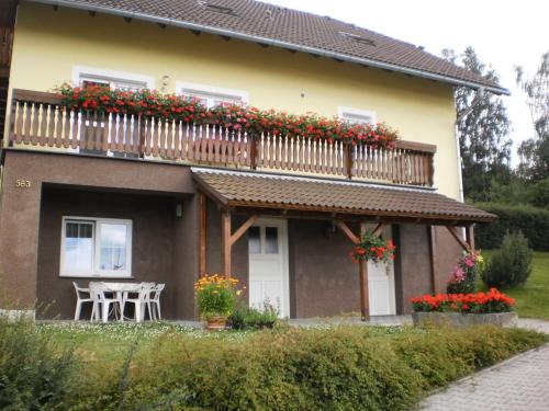 a house with a balcony with flowers on it at Apartman Kublovi in Vimperk