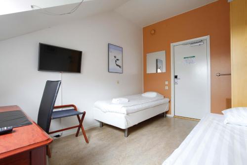 a room with a bed and a desk and a chair at Pronova Hotell & Vandrarhem in Norrköping