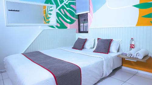 a bedroom with a large white bed with red pillows at Artemis Hotel Bekasi in Cikunir Satu