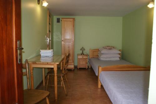a room with two beds and a table and a desk at Dom w Kwiatach in Ojców