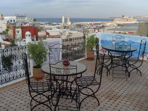 a patio with two tables and chairs on a balcony at The Medina Hostel in Tangier