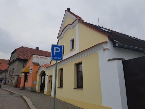 a blue parking sign in front of a yellow building at Ubytování Žižkova Pacov in Pacov