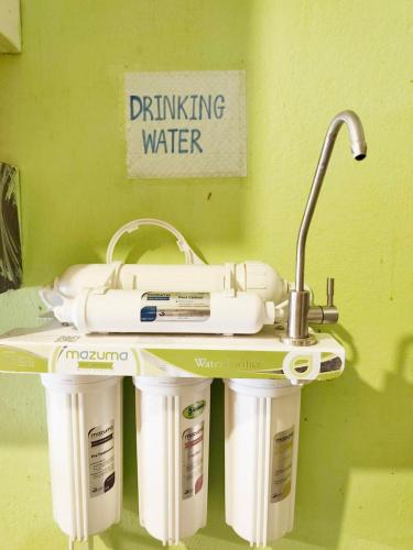 a table with three water purifiers on a wall at City Capsule Hostel in Chiang Mai