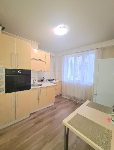 kuchnia z drewnianymi szafkami i dużym oknem w obiekcie ismail 88 w Kiszyniowie