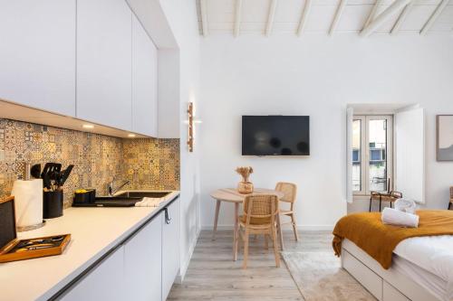 a bedroom with a bed and a kitchen with a table at Alma da Vida Ferragudo in Ferragudo