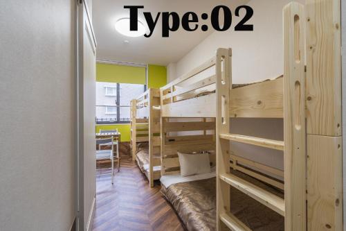 a room with two bunk beds and a table at HOTEL 萃 the 3rd-雑餉隈駅前-無人ホテル-HOTEL SUI the third-ZASSHO-Unmanned Hotel in Fukuoka