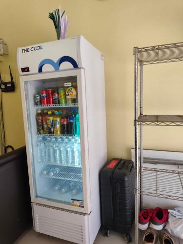 a refrigerator filled with drinks and a suitcase in a room at City Capsule Hostel in Chiang Mai