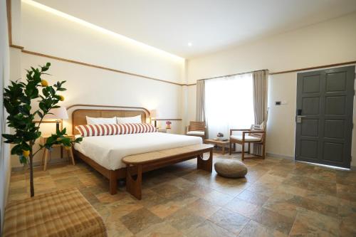 a bedroom with a bed and a large window at La Villa des Chien in Ban Nong Chap Tao