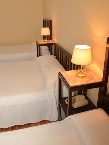 a bedroom with two beds and a table with a lamp at Argentino Hotel Casino & Resort in Piriápolis