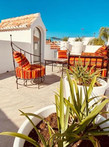 a patio with a table and chairs and plants at Alma da Vida Ferragudo in Ferragudo