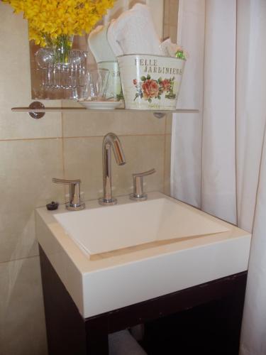 a white sink in a bathroom next to a curtain at EL Molle Hotel Boutique in Sarmiento