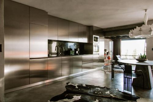a kitchen with stainless steel cabinets and a table at Luxury Waterfront Loft with Panoramic Views in Caminha
