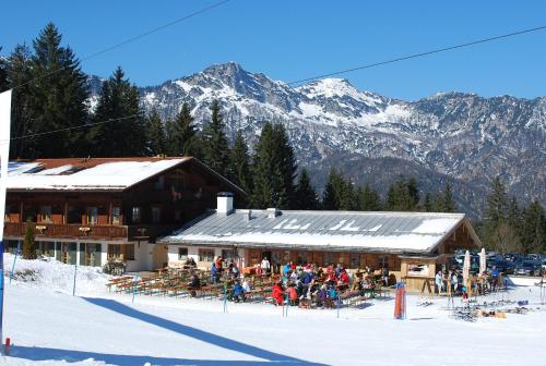 a group of people sitting outside of a ski lodge at Alpengasthof Götschenalm in Bischofswiesen