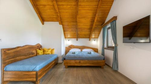 two beds in a bedroom with wooden ceilings at Villa D-Ika by Villas Guide in Brušane