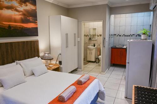 a bedroom with a white bed and a bathroom at Son Heuwel B&B room in Nelspruit