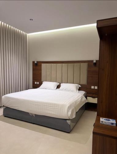 a bedroom with a large white bed in a room at Milano Hotel in Al-ʿUla