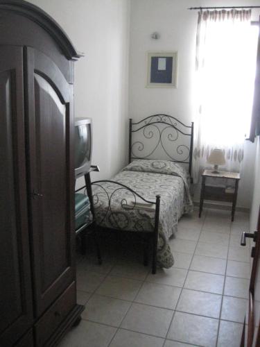 um quarto com uma cama e uma televisão em Villa Rita Bed & Breakfast em Campi Salentina