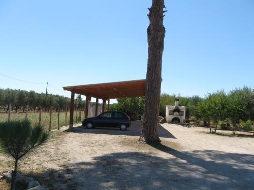 a car parked under a pavilion next to a tree at Villa Rita Bed & Breakfast in Campi Salentina