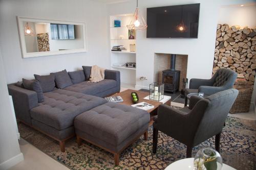 a living room with a couch and chairs and a fireplace at Albero Apartment in Eyemouth