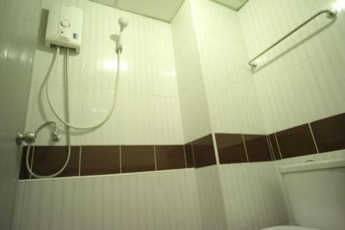 a bathroom with a shower and a toilet at Sukontha Mansion in Ban Khlong Naraphirom