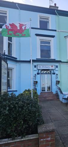 a blue building with a flag in front of it at St. Hilary Guest House in Llandudno