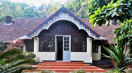 a house with a red roof and a white door at Colonial canopy in Suntikoppa