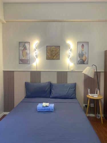 a bedroom with a blue bed with lights above it at Lolit cozy condo in Lapu Lapu City