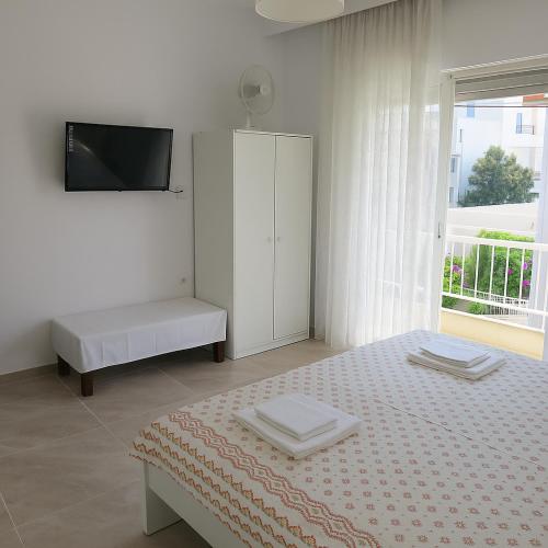 a bedroom with a bed and a cabinet and a window at Balcony Sea Hanioti Stay in Hanioti