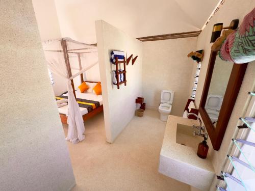 a small room with a bunk bed and a bathroom at Villa Gladys in Watamu