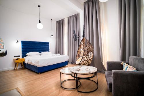a bedroom with a bed and a table and a couch at The Maroon Bottle Hotel in Thessaloniki