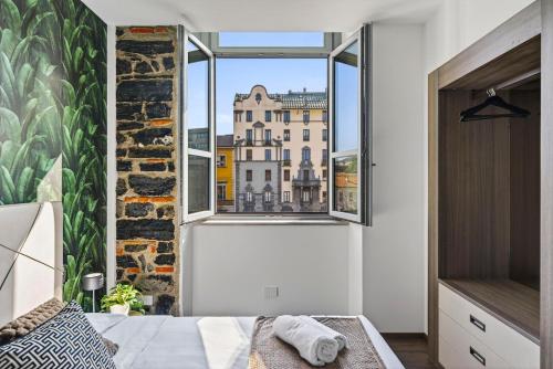 a bedroom with a window with a view of a building at Appartamento Porta Torre - Porta Torre-Centro in Como