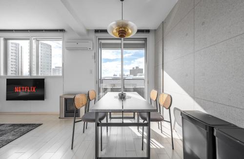 a dining room with a table and chairs and a window at Grandia 302 in Sapporo