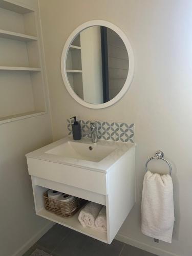 a bathroom with a white sink and a mirror at SealPoint Studio in Cape St Francis