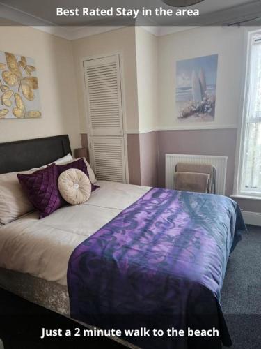 a bedroom with a bed with a purple blanket at OYO Twins Palms Guest House in Great Yarmouth