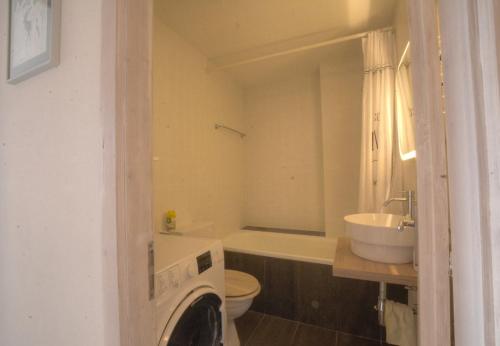 a bathroom with a sink and a toilet and a tub at Antares 402 au centre a Anzere in Anzère