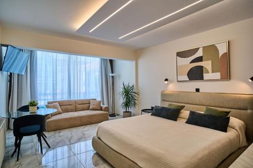 a bedroom with a bed and a couch and a table at Marianna Hotel Apartments in Limassol